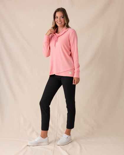 Misty Top in Spritz, full length front view featuring a solid pink waffle knit pullover with cowl neck and drawstring detail, paired with black ankle pants and white golf shoes