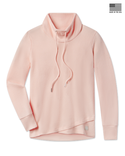 A light peach waffle-knit mock neck sweater with a drawstring.