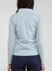 Straight Down Women's Celeste Jacket in Mineral, back view on model featuring a light sage green full-zip jacket with the Straight Down logo at the back collar, paired with navy pants