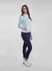 Straight Down Women's Celeste Jacket in Mineral, full length side view on model featuring a light sage green full-zip jacket with side pockets, paired with navy pants and white shoes