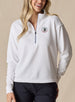 Women's 126th U.S. Open Opal Half Zip in White, front model view featuring a white waffle-knit long sleeve half zip pullover with a sage contrast zipper and the 126th U.S. Open Shinnecock Hills embroidered logo on the left chest paired with black pants