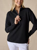 Women's Opal Half Zip in Black, front view on model featuring a black waffle-textured pullover with a quarter-zip neckline and contrast striped zipper paired with white pants