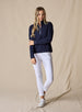 Women's Opal Half Zip in Indigo, full front view on model featuring a navy waffle-textured pullover with a quarter-zip neckline paired with white pants and white golf shoes