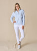 Women's Opal Half Zip in Powder, full front view on model featuring a light blue waffle-textured pullover with a quarter-zip neckline paired with white pants and white golf shoes