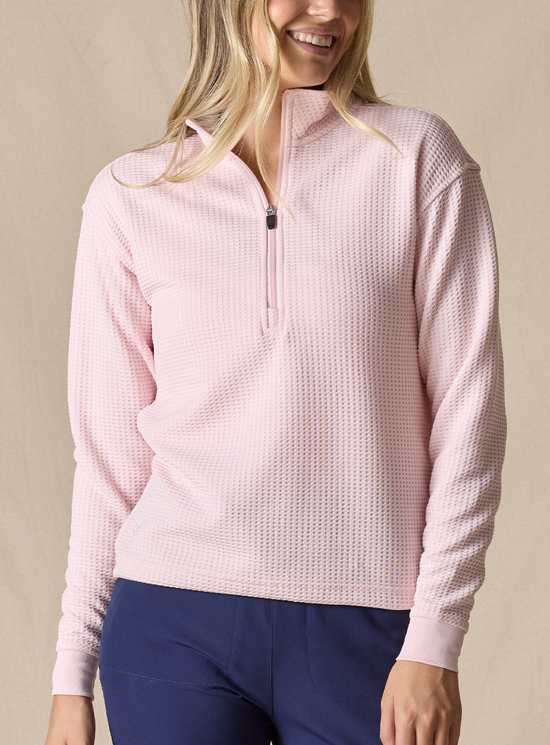 Women's Opal Half Zip in Soft Pink, front view on model featuring a light pink waffle-textured pullover with a quarter-zip neckline paired with navy pants