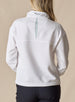 Women's Opal Half Zip in White, back view on model featuring a white waffle-textured pullover with an embroidered logo at the collar and a sage green back vent detail paired with black pants