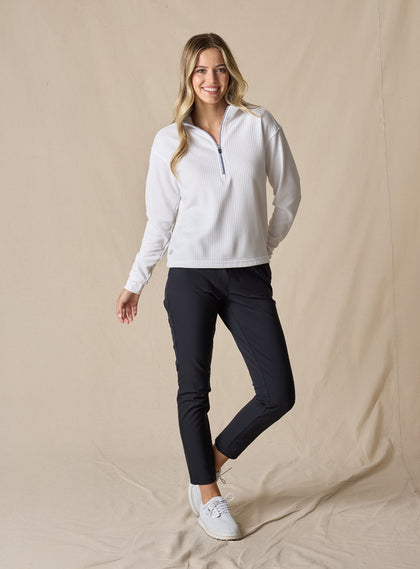 Women's Opal Half Zip in White, full front view on model featuring a white waffle-textured pullover with a quarter-zip neckline paired with black pants and white golf shoes