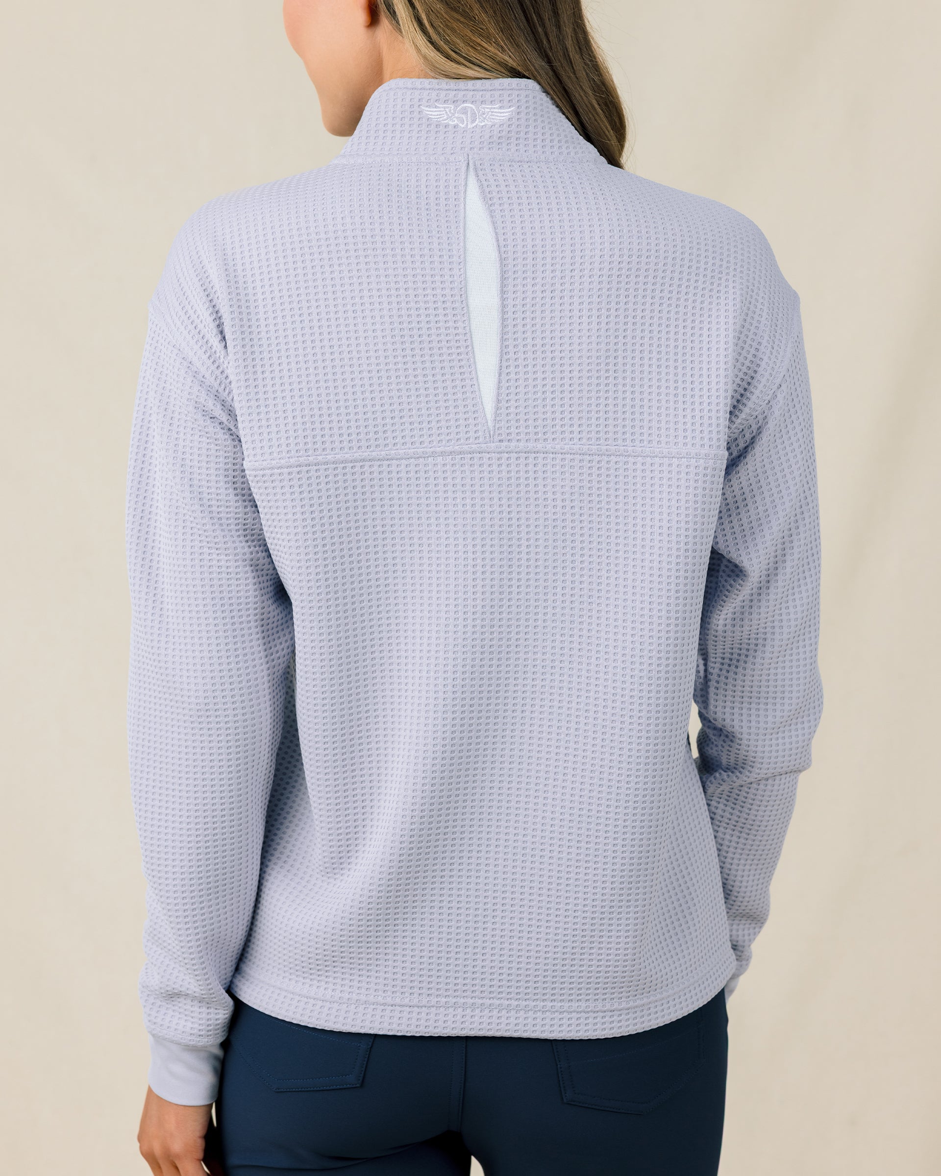 Back view of the Straight Down Opal Half Zip in Cosmic Blue showcasing the textured waffle knit fabric, vented back opening, and embroidered logo at the collar