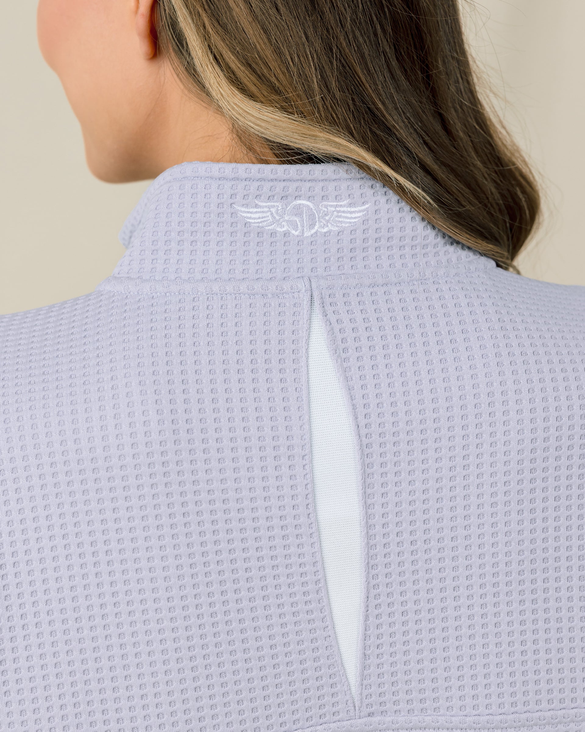 Close-up of the Straight Down Opal Half Zip in Cosmic Blue highlighting the vented back opening and embroidered logo at the mock neck collar