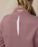 Close-up of the Straight Down Opal Half Zip in Oxblood Red highlighting the vented back opening and embroidered logo at the mock neck collar