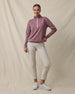 Woman wearing the Straight Down Opal Half Zip in Oxblood Red with a contrast half-zip mock neck and light golf pants