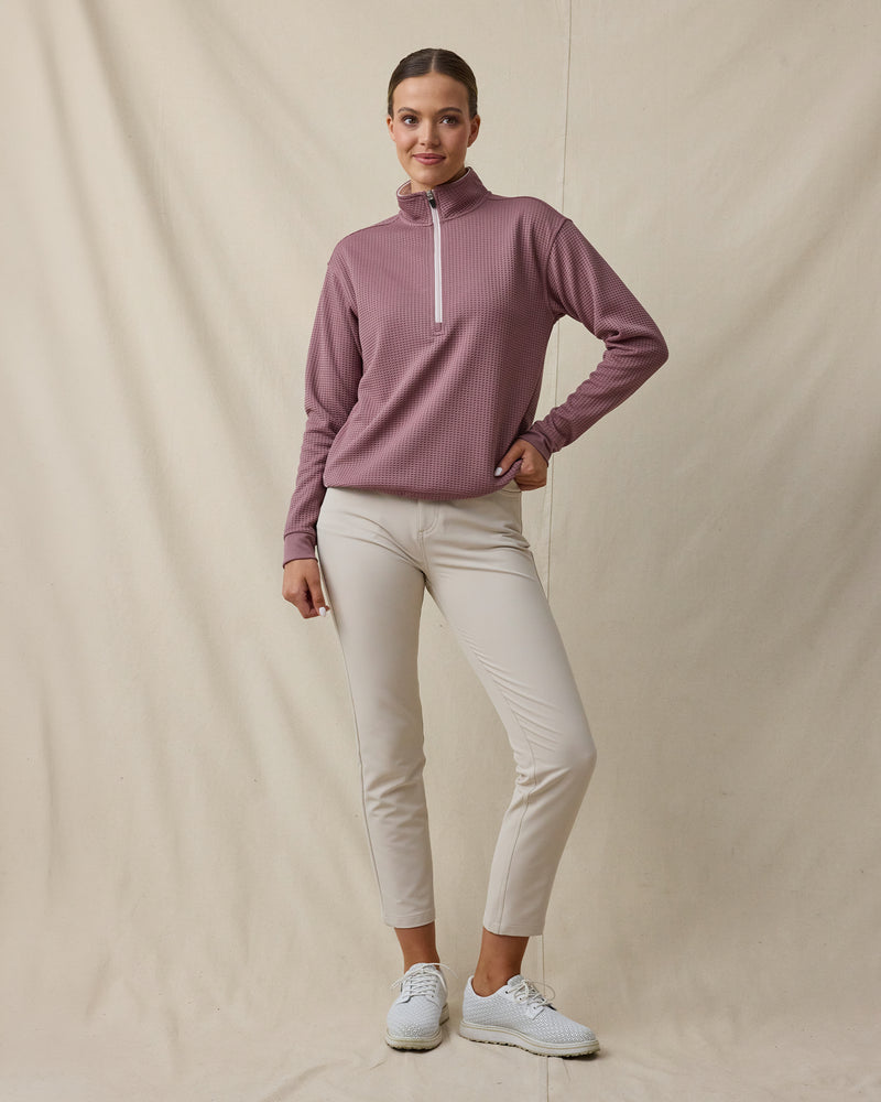 Woman wearing the Straight Down Opal Half Zip in Oxblood Red with a contrast half-zip mock neck and light golf pants