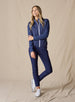 Women's Hera Jacket in New Indigo, full-length front view on model featuring a diamond quilted front body with solid navy knit sleeves and white zipper and trim detail, paired with matching navy pants and white shoes