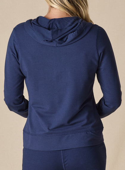 Women's Mesa Hooded Jacket in New Indigo, back model view featuring a navy full-zip hoodie with drawstring hood, clean back panel, ribbed hem, and long sleeves paired with matching pants