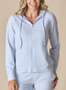 Women's Mesa Hooded Jacket in Powder, front model view featuring a soft blue full-zip hoodie with drawstring hood, center zip closure, and long sleeves paired with matching pants