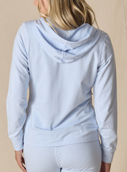 Women's Mesa Hooded Jacket in Powder, back model view featuring a soft blue full-zip hoodie with drawstring hood, clean back panel, ribbed hem, and long sleeves paired with matching pants