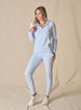 Women's Mesa Hooded Jacket in Powder, full length model view featuring a soft blue full-zip hoodie with drawstring hood paired with matching pants and white athletic shoes