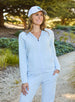 Women's Mesa Hooded Jacket in Powder, outdoor lifestyle model view featuring a soft blue full-zip hoodie with drawstring hood paired with matching pants and a white Straight Down logo hat