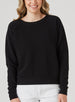 Delia Sweatshirt in Black, front view on model featuring a black ribbed-texture crewneck pullover with raglan sleeves and ribbed hem styled with white pants