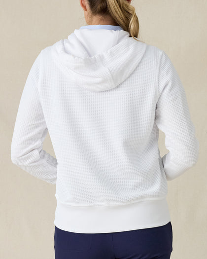 Eliza Hoodie in White, back view on model showing a white waffle-knit full zip hoodie with drawstring hood, paired with navy pants