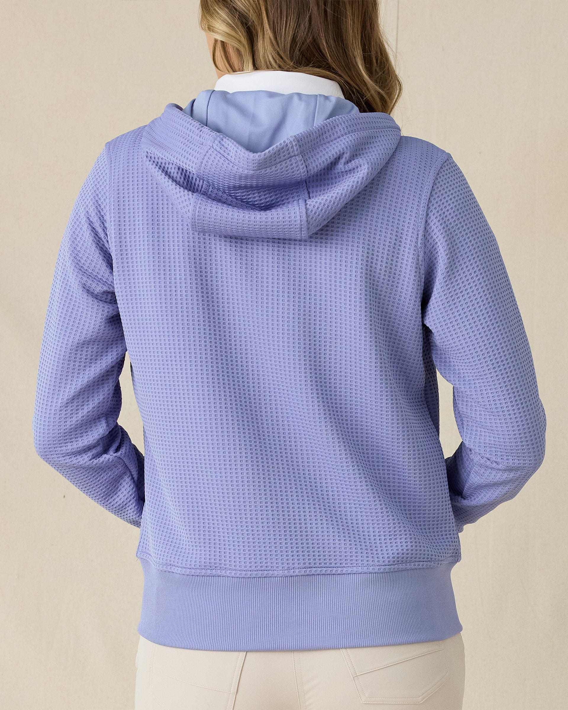 Eliza Hoodie in Blue Shade, back view on model in solid blue waffle knit texture with drawstring hood, layered over a white polo