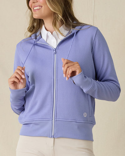 Eliza Hoodie in Blue Shade, front view on model in solid blue waffle knit texture with full zip and drawstring hood, layered over a white polo