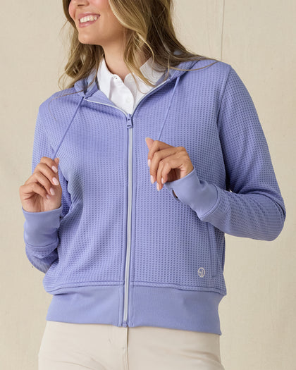 Eliza Hoodie in Blue Shade, front view on model in solid blue waffle knit texture with full zip and drawstring hood, layered over a white polo