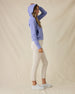 Eliza Hoodie in Blue Shade, full-length side view on model in solid blue waffle knit texture with hood up, paired with cream pants and white golf shoes
