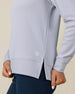 Close-up of the Daria Hoodie in Cosmic Blue showing the waffle-knit texture, side slit hem, and embroidered logo