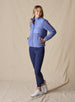 Women's Laurel Hybrid Fleece Jacket in Blueberry, full body front view on model featuring a medium blue quilted upper body with fleece lower body and sleeves paired with navy pants and white golf shoes