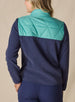 Women's Laurel Hybrid Fleece Jacket in Sea Green and New Indigo, back view on model featuring a sea green quilted upper back panel with navy fleece lower body and an embroidered Straight Down logo at the collar paired with navy pants