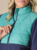 Women's Laurel Hybrid Fleece Jacket in Sea Green and New Indigo, close-up front detail view featuring the sea green diamond quilted upper body panel and contrast navy full-zip closure