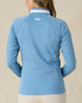 Patty Jacket in Coastal, back view on model featuring a solid medium blue full zip jacket with white piping along the sleeves and Straight Down embroidered logo at the upper back, paired with khaki pants