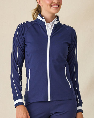 Patty Jacket in New Indigo, front view on model in solid navy with white contrast piping and full zip, layered over a white polo
