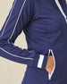 Patty Jacket in New Indigo, close-up detail view on model featuring white contrast piping along the sleeve, white striped cuff, and zip pocket