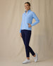 Women's Eirene Jacket in Carolina, full length side view on model featuring a light blue full-zip jacket with mock neck collar and zippered side pockets, paired with navy pants and white golf shoes