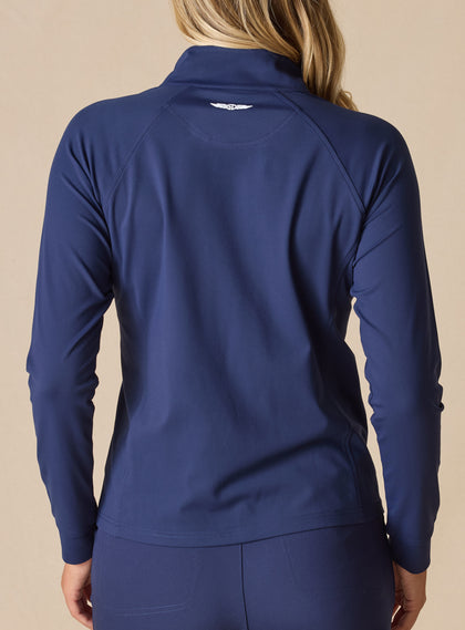 Women's Eirene Jacket in New Indigo, back view on model featuring a solid navy performance fabric with raglan sleeve construction and white Straight Down logo at the upper back, paired with matching navy pants