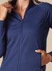 Women's Eirene Jacket in New Indigo, close-up detail view featuring the full-zip stand collar and raglan sleeve construction with model's hand in the zippered side pocket, showcasing the solid navy performance fabric