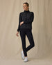 Women's Ida Hybrid Jacket in Black, full length side angle view on model featuring a black full zip hybrid jacket with a quilted front body panel, paired with black pants and white golf shoes