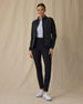 Women's Ida Hybrid Jacket in Black, full length front view on model featuring a black full zip hybrid jacket worn open over a light blue polo, paired with black pants and white golf shoes