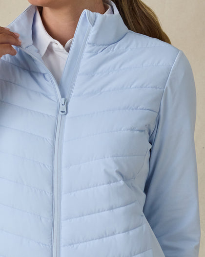 Women's Ida Hybrid Jacket in Lake, detail close-up view featuring the quilted puffer front body construction, mock neck collar, and tonal full-zip closure, layered over a white polo