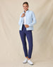 Women's Ida Hybrid Jacket in Lake, full length front view on model featuring a light blue hybrid jacket with quilted puffer front body worn open, layered over a white polo, paired with navy pants and white golf shoes