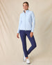 Women's Ida Hybrid Jacket in Lake, full length side view on model featuring a light blue hybrid jacket with quilted puffer front body and stretch knit sleeves, paired with navy pants and white golf shoes
