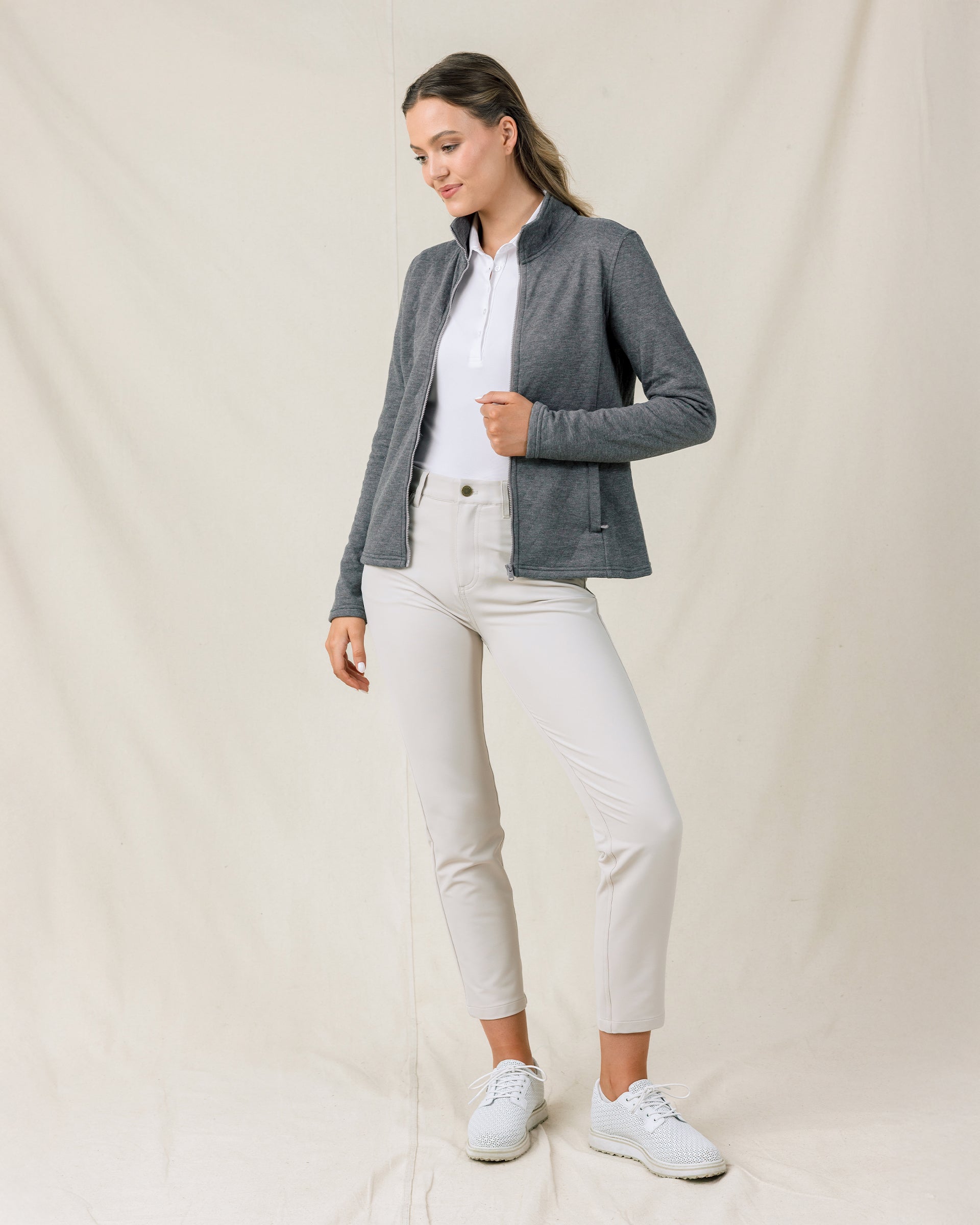 Full-length view of a model wearing the Marlow Jacket in Nightshade open over a white polo with light-colored pants and golf shoes.