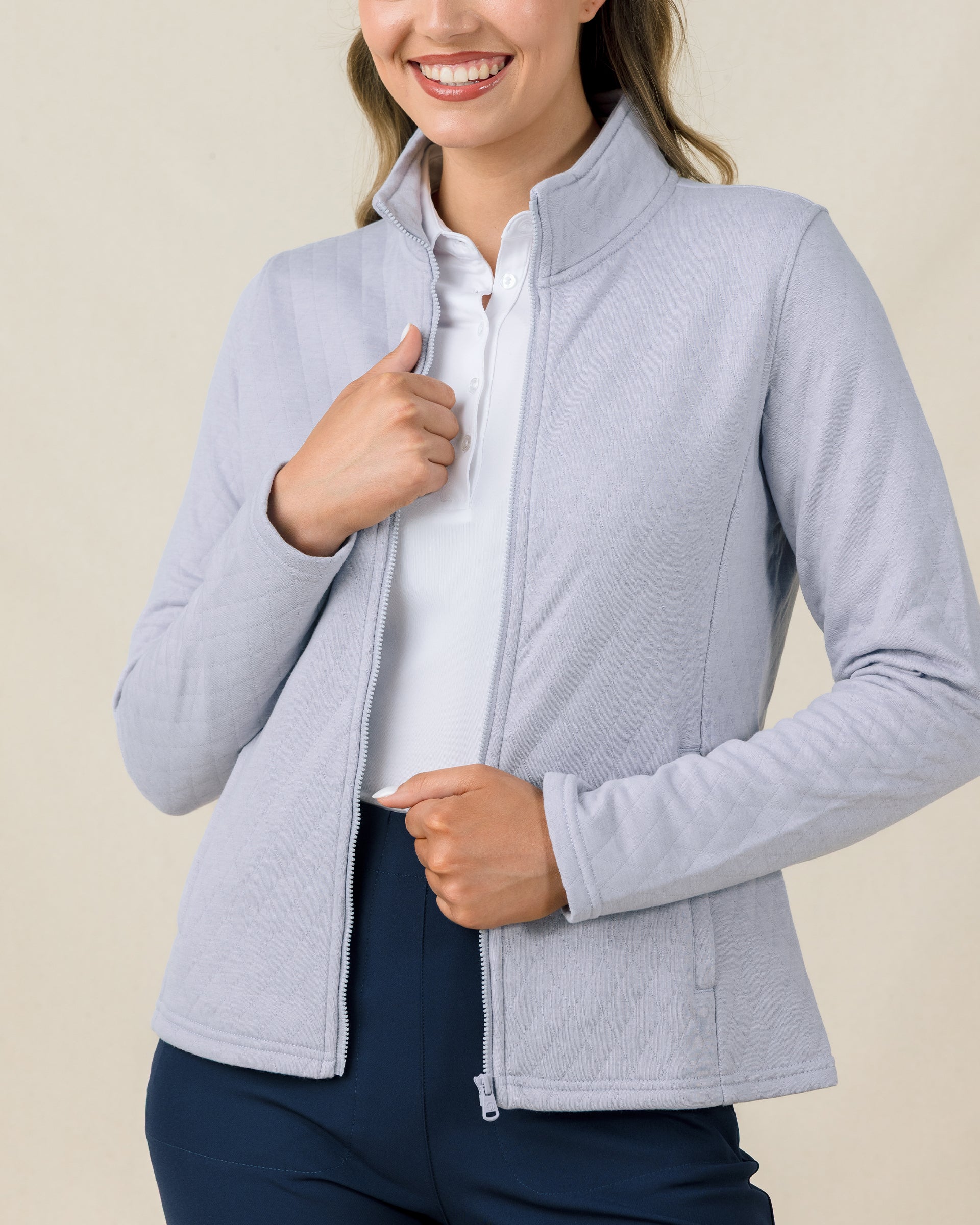 Woman wearing the Straight Down Marlow Jacket in Cosmic Blue unzipped over a white polo