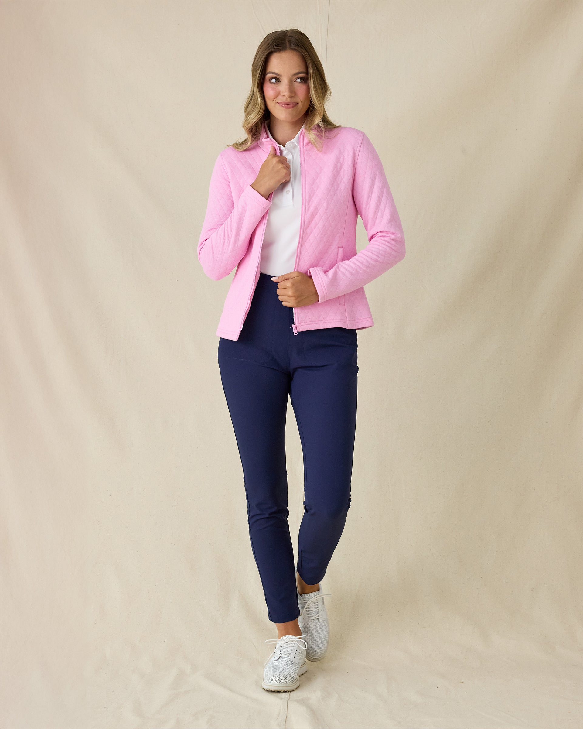 Marlow Jacket in Pink Floyd, full-length front view on model in solid pink diamond quilt texture with zip open, layered over a white polo, paired with navy pants and white golf shoes