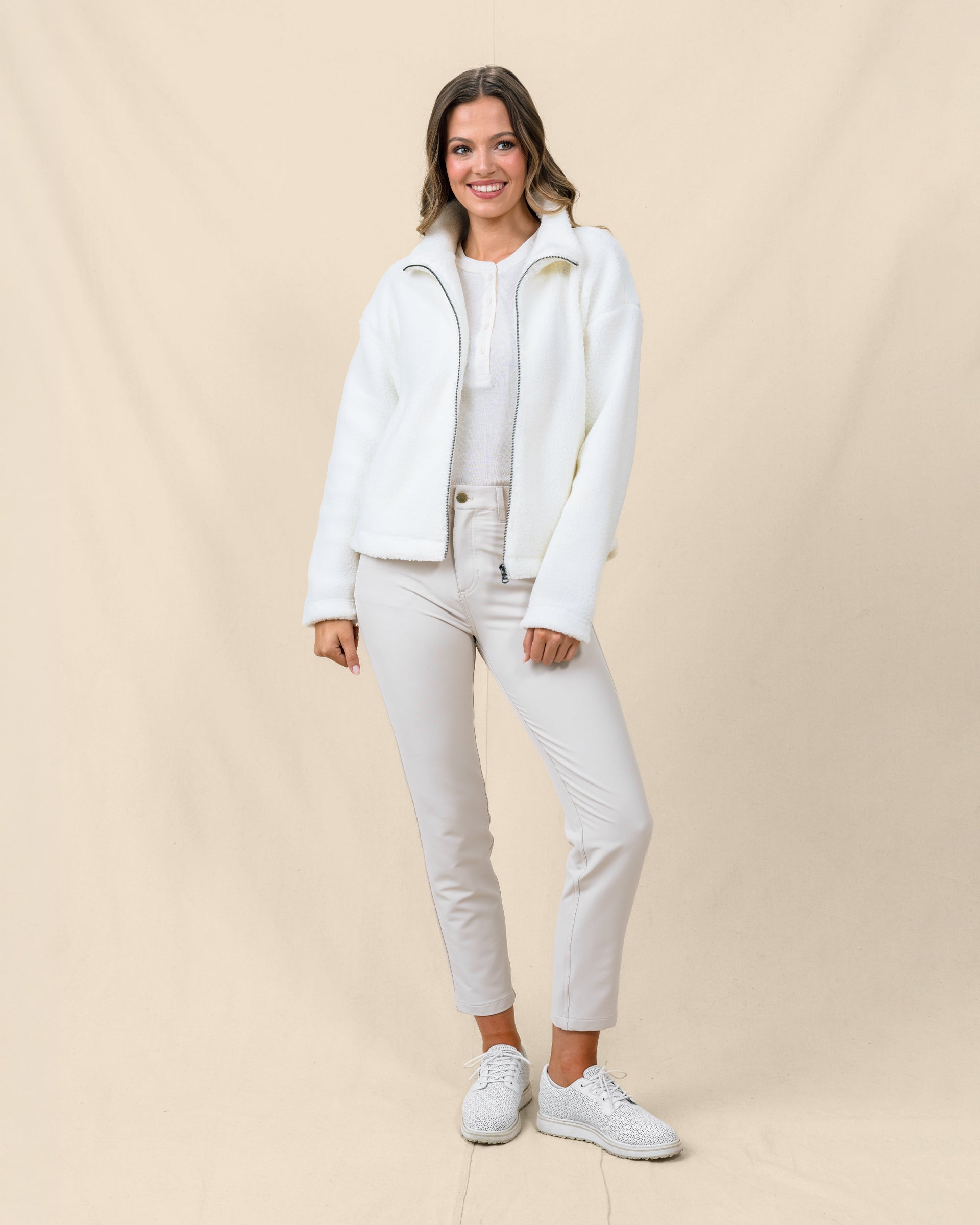 Model wearing the Kemble Fleece Jacket in Coconut unzipped over a knit top