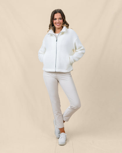 Model wearing the Kemble Fleece Jacket in Coconut zipped with golf pants for a cozy cool-weather outfit