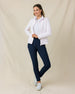 Woman wearing the Straight Down New Swing Jacket in Pale Pink unzipped over a white polo with navy golf pants