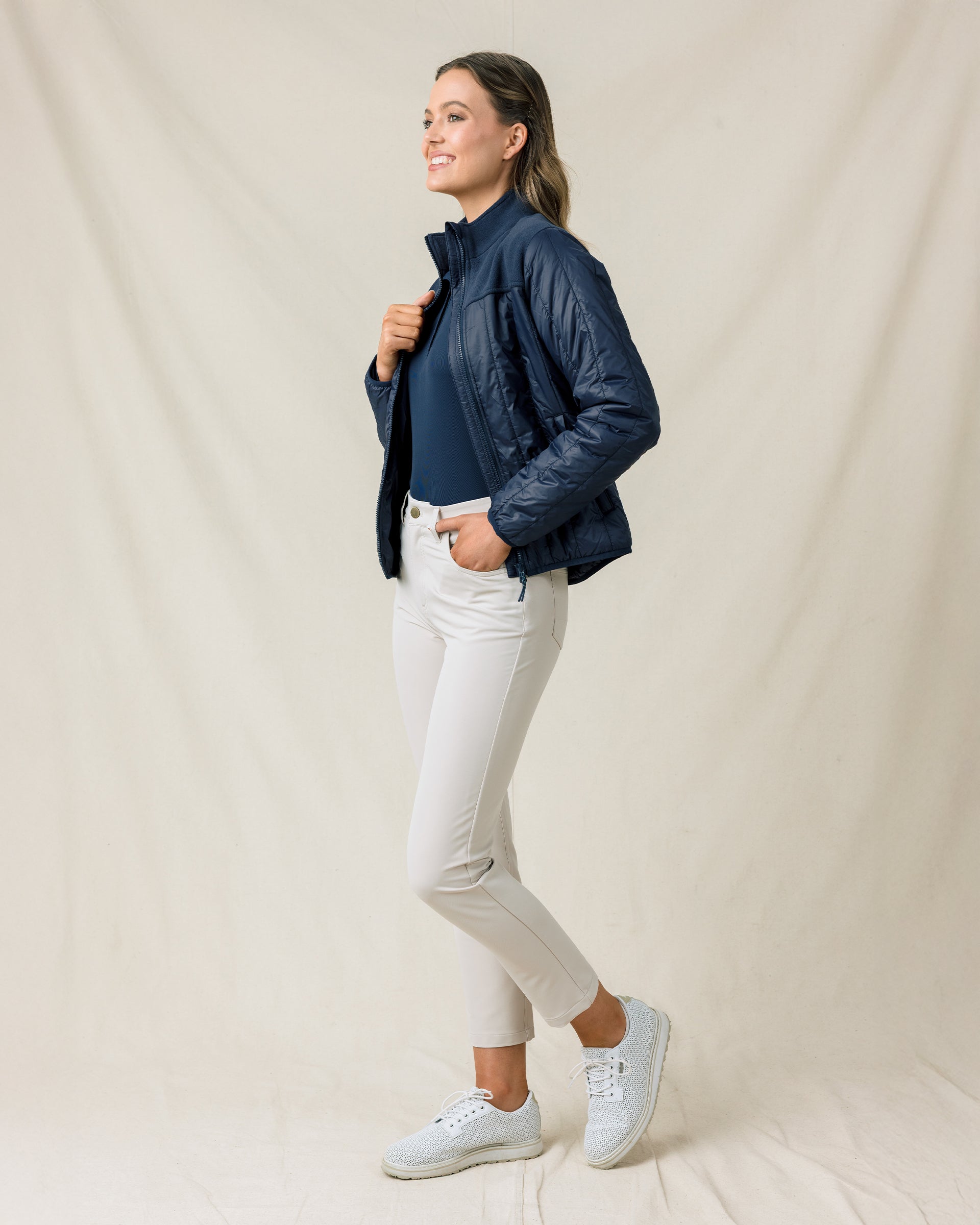 Woman wearing the Straight Down Taylor Jacket in New Indigo with light golf pants in a side profile